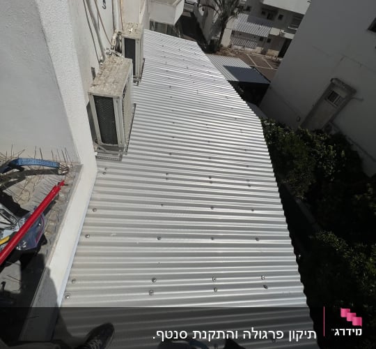 גג מתכת גלי עם ציוד עבודה וחבלים